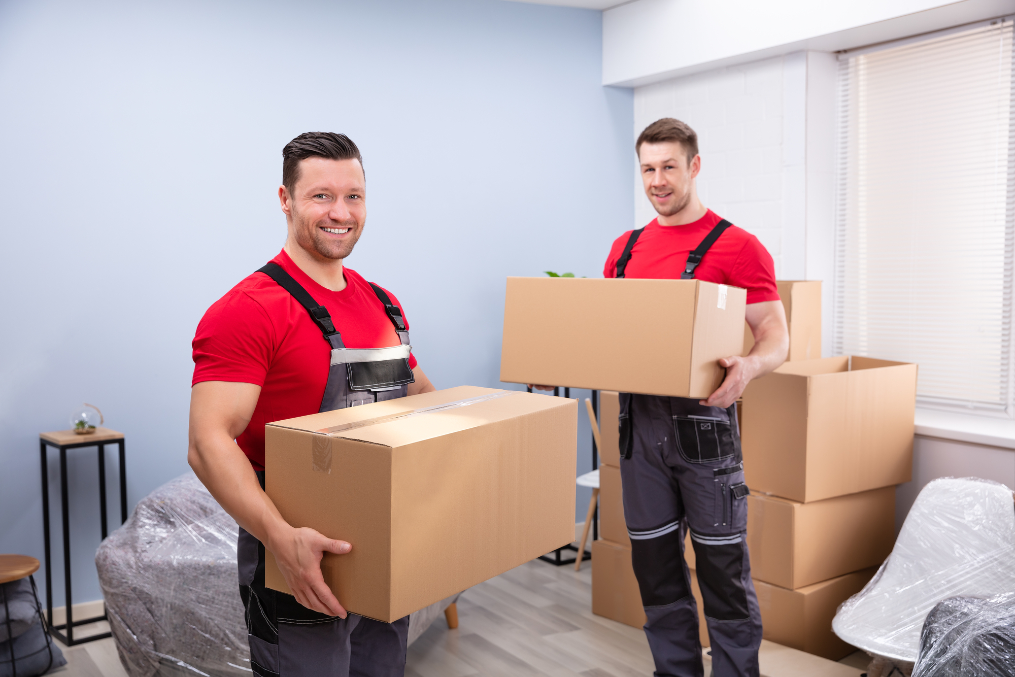 Smiling Young Male Relocation Worker Carrying Cardboard Boxes