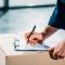 courier filling cargo declaration on cardboard package Moving Services in California